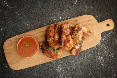 Lezzetli tavuk kanatları, fırında ya da kızarmış tavuk kanadı sıcak baharatlı barbekü sosuyla servis edilir.