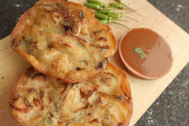 Bakwan Goreng, Endonezya usulü kızarmış sebze hamur tatlısı, aperatif, geleneksel sokak yemekleri sambal veya chili sosu ve ahşap tabakta çiğ kırmızı biber ile servis ediliyor.