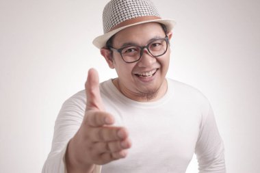 Beyaz arka planda el sıkışan ve gülümseyen Asyalı genç adamın portresi, seçici odak resmi, anlaşma konsepti