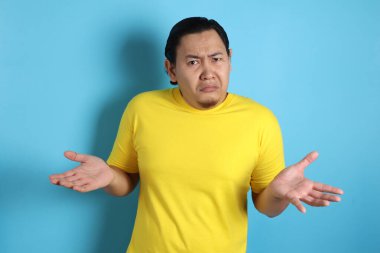 Komik Asya adam omuz silkme omuz jest, ben bilmiyorum gösteren veya ret ile fotoğraf görüntü