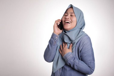 Başörtüsü takan müslüman bir kadının portresi telefonda konuşuyor, mutlu bir gülümseme, iyi haberler var, beyazlar üzerinde izole edilmiş.