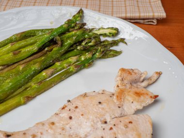 Tavuk göğsü ve kavrulmuş yeşil kuşkonmaz.