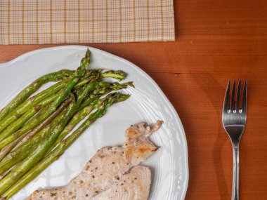 Tavuk göğsü ve kavrulmuş yeşil kuşkonmaz.