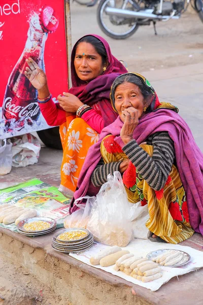 AMBER, INDIA - 13 DE NOVIEMBRE: Mujeres no identificadas venden alimentos para peces — Foto de Stock