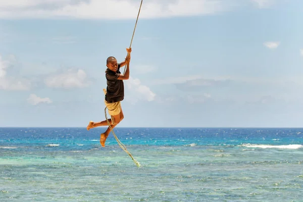 LAVENA, FIJI - NOVEMBER 27: Unidentified boy swings on a rope sw — Stock Photo, Image