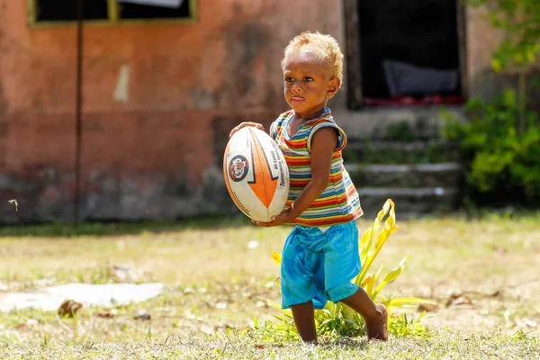 LAVENA, FIJI - 27 DE NOVIEMBRE: Niño no identificado juega con el rugby ba — Foto de Stock