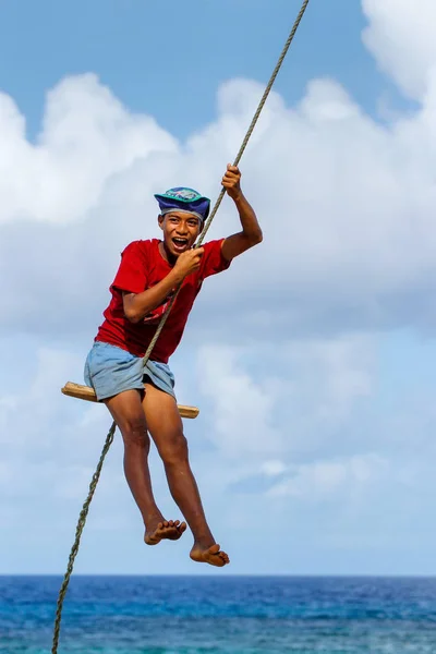 LAVENA, FIJI - 27 NOVEMBRE: Ragazzo non identificato oscilla su una corda sw — Foto Stock