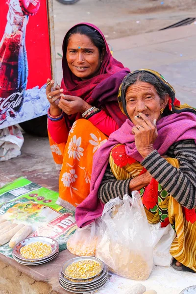 AMBER, INDIA - 13 DE NOVIEMBRE: Mujeres no identificadas venden alimentos para peces — Foto de Stock