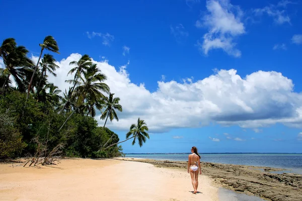 Ung kvinna i bikini promenader på stranden vid Makaha'a ön ne — Stockfoto