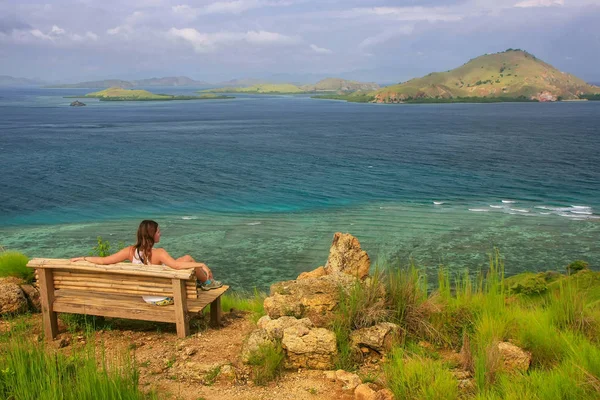 Ung kvinna sitter på en bänk på utsiktsplatsen på Kanawa Island — Stockfoto