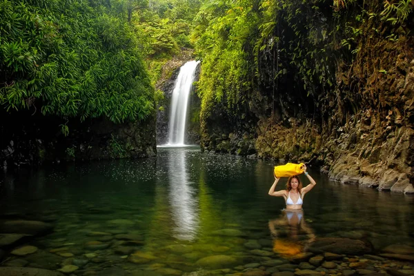 Jeune femme marchant à travers la lagune avec un sac sec à Wainibau Wa — Photo