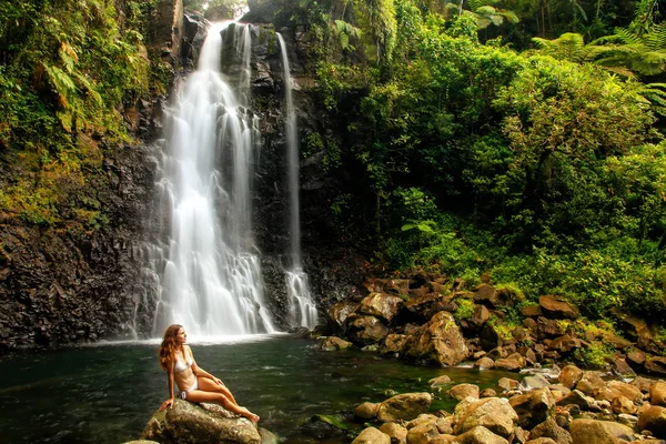 Jeune femme en bikini assise près des chutes d'eau Middle Tavoro à Bou — Photo