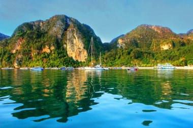 Ao Loh Dalum Bay surrounded by limestone formations on Phi Phi D clipart
