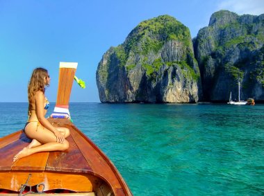Maya Bay longtail teknenin önünde oturan genç kadın