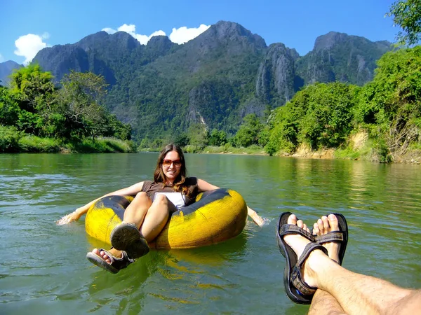 Paar begibt sich in einer Röhre, die von Karst umgeben ist, den Fluss nam song hinunter — Stockfoto