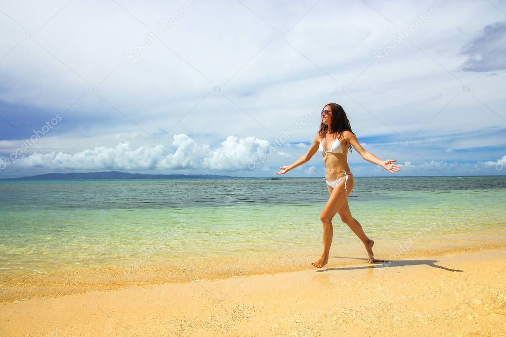 Young woman in bikini running on the beach, Taveuni Island, Fiji