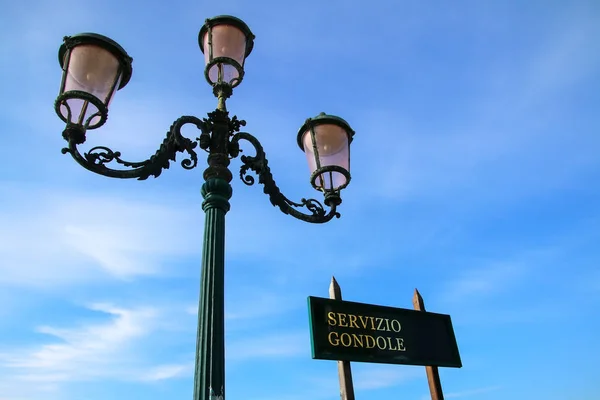 Gondola služby znamení a ulici lampa proti modré obloze poblíž Piazzy — Stock fotografie