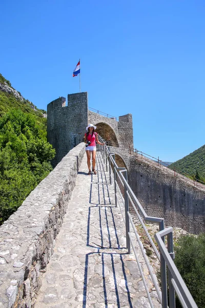 Mladá žena chůze na obranné zdi města Ston, Peljesac — Stock fotografie