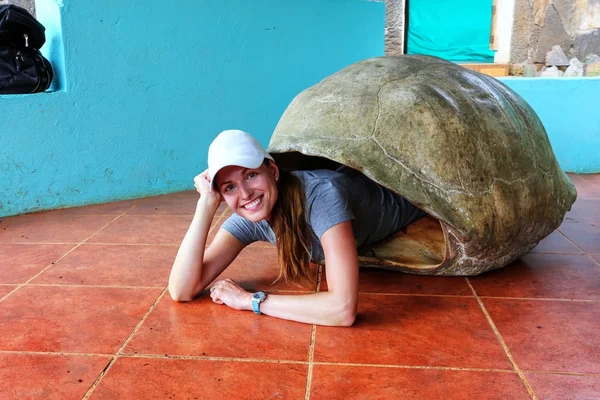 Woman lying inside empty Galapagos giant tortoise shell at the s — Stock Photo, Image