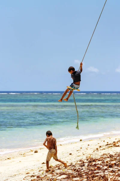 Lavena, Fiji - 27 November: Onbekende jongen schommels op een touw-sw — Stockfoto
