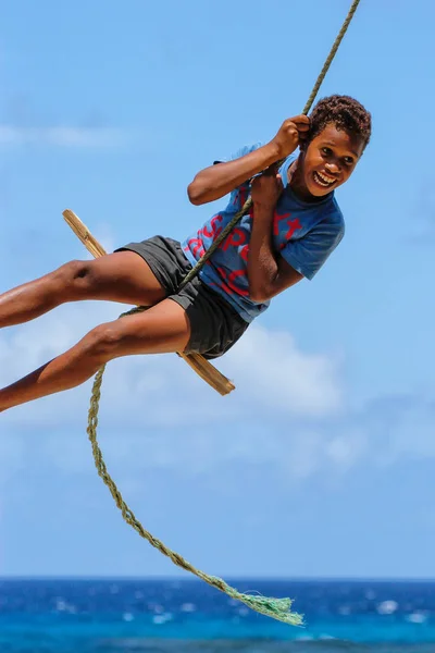 LAVENA, FIJI - 27 DE NOVIEMBRE: Un niño no identificado se balancea sobre una soga — Foto de Stock