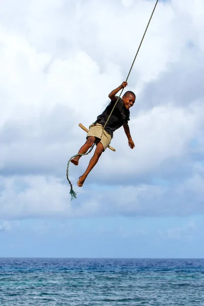 LAVENA, FIJI - NOVEMBER 27: Unidentified boy swings on a rope sw — Stock Photo, Image