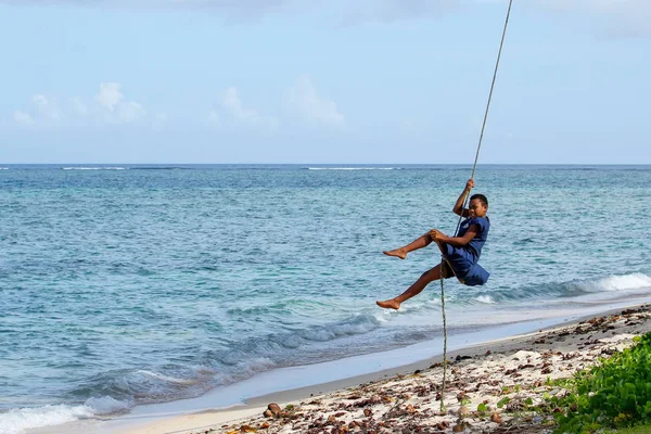 LAVENA, FIJI - 27 DE NOVIEMBRE: Un niño no identificado se balancea sobre una soga — Foto de Stock