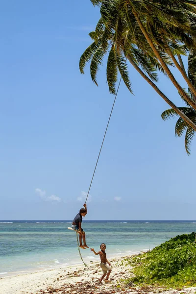 Lavena, Fidżi - 27 listopada: Niezidentyfikowany chłopiec huśtawki na sw liny — Zdjęcie stockowe