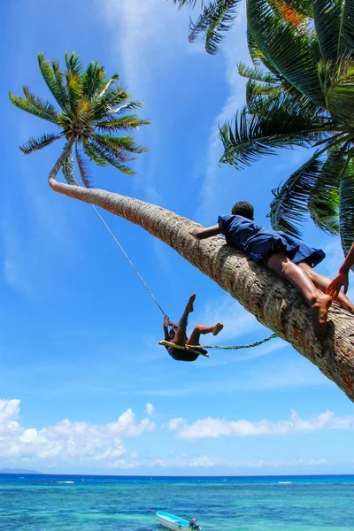 Lokala barn gungar på ett rep svinga i Lavena by, Taveuni jag — Stockfoto