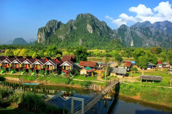 Fila di bungalow turistici lungo il fiume Nam Song a Vang Vieng, Vie — Foto Stock