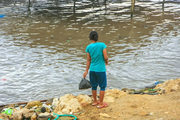 Local woman throwing garbage in the sea in Labuan Bajo town, Flo — Stock Photo, Image