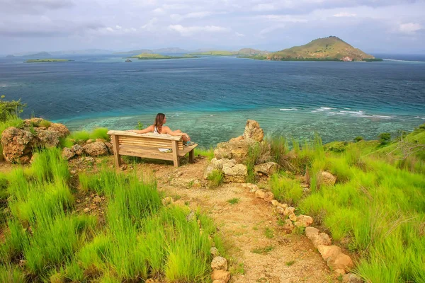 Mujer joven sentada en un banco en el mirador de la isla de Kanawa — Foto de Stock