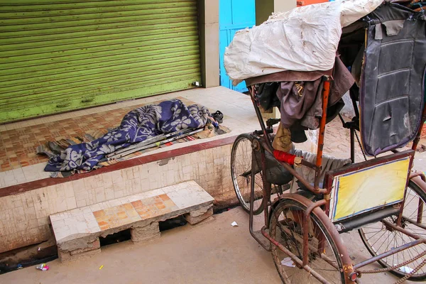 Homeless person sleeping under blanket in the street in Taj Ganj neighborhood of Agra, Uttar Pradesh, India. Agra is one of the most populous cities in Uttar Pradesh