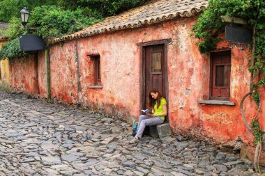 Calle de los Suspiros (Street of Sighs) Colonia del Sacramento, Uruguay'da oturan bir genç bayan. Uruguay'nın en eski şehirlerinden biridir