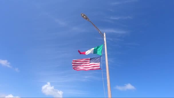 メキシコとアメリカの旗は メキシコのコスタマヤのマホアル村のクルーズ船ターミナルで一緒に飛んでいます — ストック動画