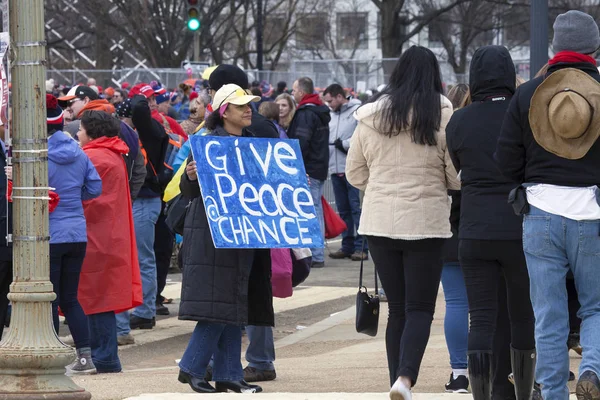 Woman carries peace sign during inauguration of Donald Trump — Stock Photo, Image