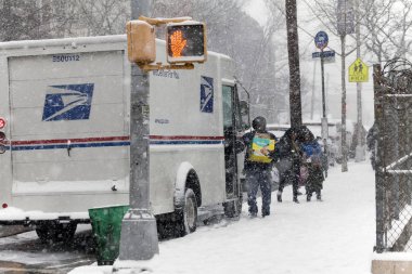 Postacı paket kar fırtınası içinde sunar.