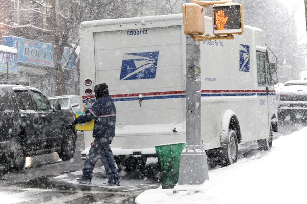 Listonosz z pakietem podczas burzy śnieżnej — Zdjęcie stockowe