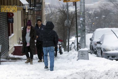 İnsanlar cadde boyunca kar fırtınası sırasında yürüyüş.