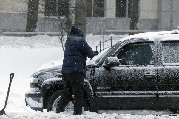 Man rengör bilen med borste under snöstorm — Stockfoto