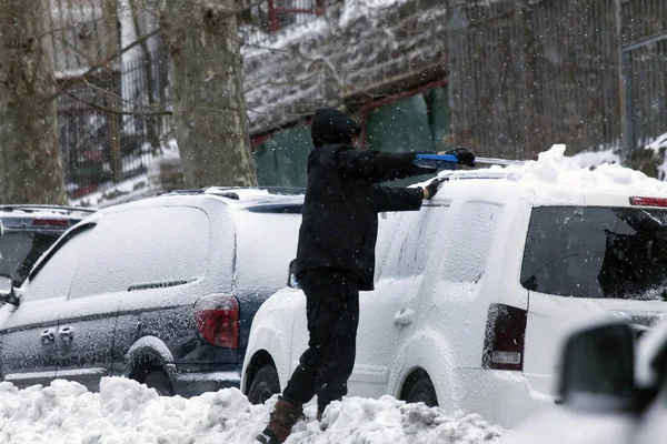 Man cleans car during snow storm — Stock Photo, Image