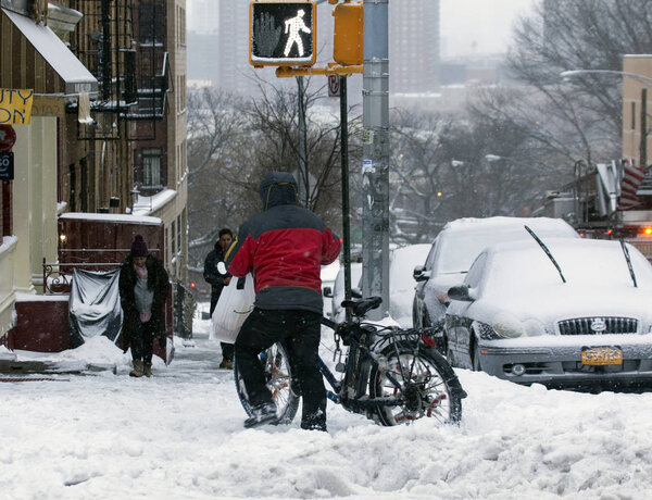 BRONX, NEW YORK - MARCH 14: People walk along street during snow storm. Taken March 14, 2017 in New York.