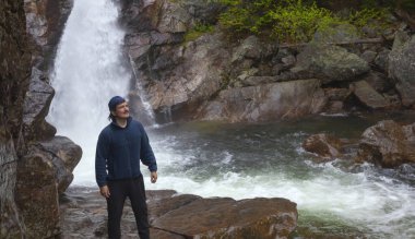 Adam Ne Pinkham çentik at Glen Ellis Falls önünde ayakta