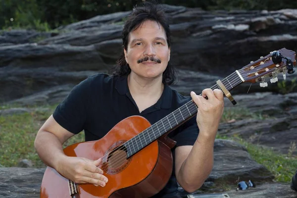 Hombre hispano tocando la guitarra acústica al aire libre — Foto de Stock