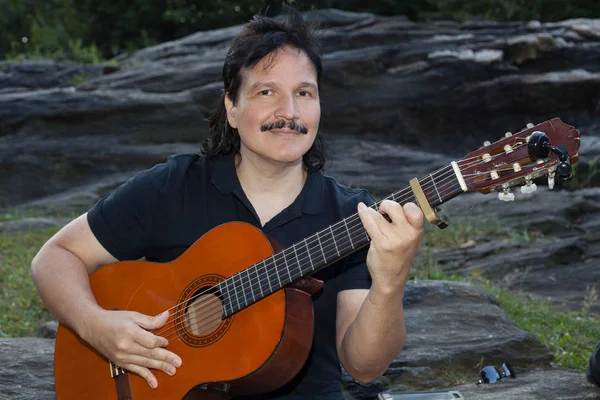 Hombre hispano tocando la guitarra acústica al aire libre — Foto de Stock