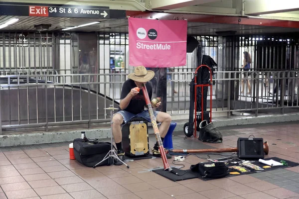 Subway performer blows into a didgeridoo in NYC — Stock Photo, Image