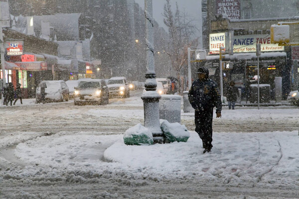 BRONX, NEW YORK - MARCH 7: Minority man crosses street during snow storm. Taken March 7, 2018 in New York.