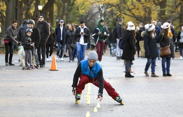 アジア人はセントラルパークでローラースケートの障害物を設定します。 — ストック写真