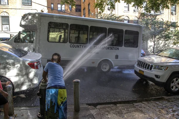 Young child plays with hydrant water during summer in NYC — Stock Photo, Image