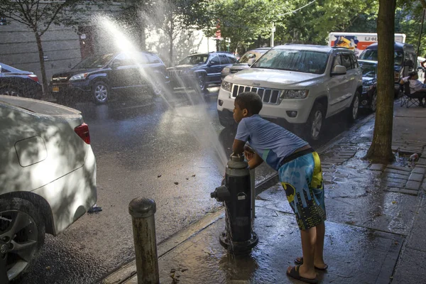 Young child plays with hydrant water during summer in NYC — Stock Photo, Image